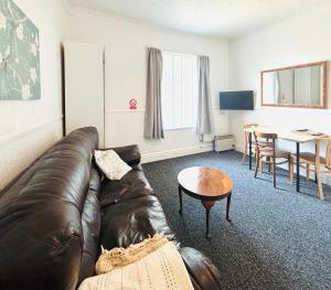 a living room with a leather couch and a table at Springfield Holiday Apartments HALodge Hotel in Skegness