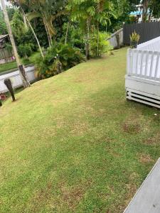 a white bench sitting in the grass near a yard at MalaudeAirBNB in Suva