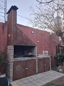 a brick pizza oven in a red wall at Monoambientes CDM in Capilla del Monte +2 photos