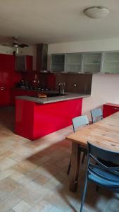 a kitchen with a red counter and a wooden table at Gigli di mare in Santa Severa