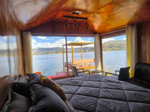 a bedroom with a bed and a view of the water at Uros Quechua`s Lodge Titicaca in Puno