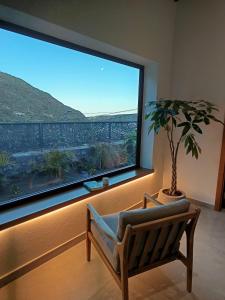 a room with a chair and a large window at Natura Luxury in Las Lagunetas