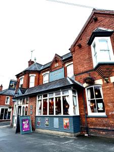 Un edificio de ladrillo con un cartel delante. en Cosy Lincoln Home Sleeps 6 with Parking, en Boultham