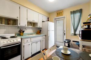 a kitchen with white cabinets and a table with a dining room at Sunny 1BR Hollywood Retreat – Pet Friendly in Hollywood