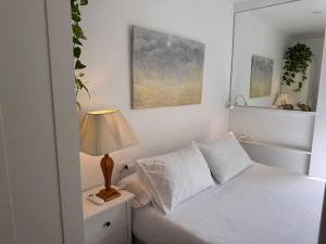 Un dormitorio con una cama y una lámpara en una mesita de noche. en Casa La Victoria, en Málaga