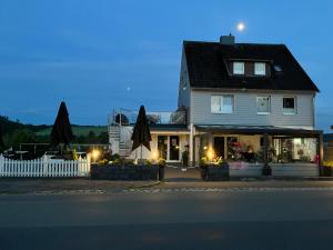 a house with a white fence and a building at Mellys Café & Store in Einbeck