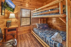 een slaapkamer in een blokhut met een stapelbed en een tv bij Majestic Views Holiday home in Gatlinburg