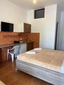 a bedroom with a bed and a desk and a kitchen at Enes Apartments in Ulcinj