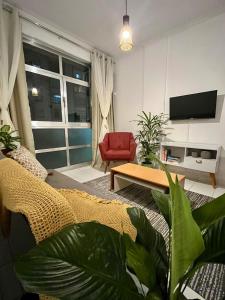 Studio Brisa - Vista Mar Canal 5 - Santos في سانتوس: غرفة معيشة مع أريكة وكرسي احمر