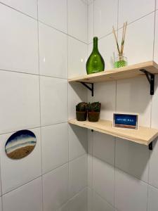 Studio Brisa - Vista Mar Canal 5 - Santos في سانتوس: غرفة ذات جدران من البلاط الأبيض ورفوف خشبية +35 صورة