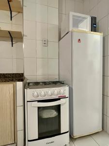 Studio Brisa - Vista Mar Canal 5 - Santos في سانتوس: مطبخ مع موقد ابيض وثلاجة