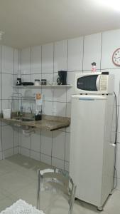 a kitchen with a microwave on top of a refrigerator at Refúgio da Light in Carmo