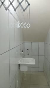 a white bathroom with a sink and a glass wall at Refúgio da Light in Carmo +8 photos