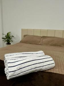 Studio Brisa - Vista Mar Canal 5 - Santos في سانتوس: سرير عليه بطانية بيضاء وسوداء