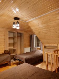 a bedroom with two beds in a wooden room at Hotel alisa in racha in Oni
