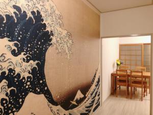 a painting of a wave on the wall in a dining room at Station Front JUSO EAST 402 No Lift in Osaka