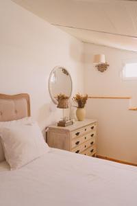 a bedroom with a bed and a dresser with a mirror at Casa das Maria's - Casas com EnCanto in Reguengos de Monsaraz