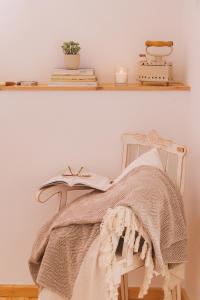 a chair with a blanket and a book on it at Casa das Maria's - Casas com EnCanto in Reguengos de Monsaraz
