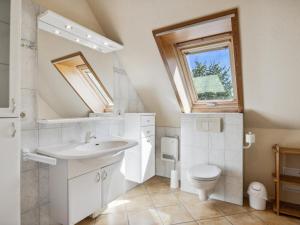 a bathroom with a sink and a toilet and a window at Nordlicht - Leuchtturm OG in Timmendorf