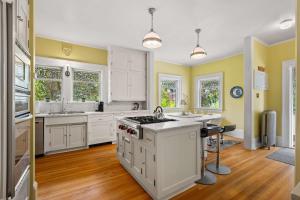 cocina con paredes amarillas y armarios blancos en Historic Treend Residence in the heart of Mission Calgary, en Calgary