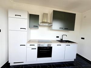 Una cocina con gabinetes blancos y un fregadero. en Cozy Apartment in Zeltweg for MotoGP, en Zeltweg 12 fotos más