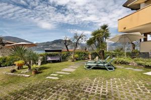 a patio with a lawn chair and an umbrella at Lake Garda Apartment - Panorama in Brenzone sul Garda