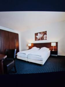 a hotel room with a bed and a chair at Hotel&Spa am Oppspring in Mülheim an der Ruhr