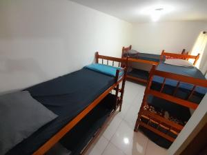 a bedroom with two bunk beds in a room at Casa 2qts Churrasqueira Condomínio Pássaros Peró in Cabo Frio