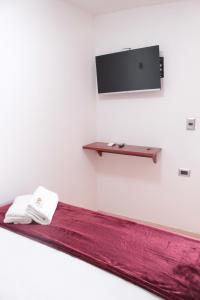 a room with a bed with a tv on a wall at Hospedaje san gabriel in Barranquilla