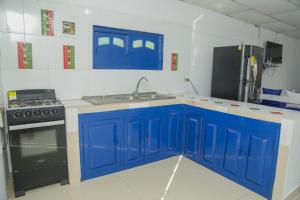 a kitchen with blue cabinets and a sink and a stove at Cabaña Palma Azul in Coveñas