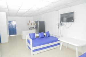 a hospital room with a blue couch and a table at Cabaña Palma Azul in Coveñas