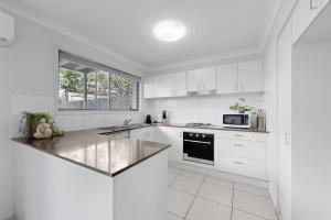 北湖Modern Homely Townhouse with Pool Access & Free WIFI的白色的厨房配有白色的橱柜和台面