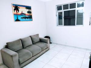a living room with a couch and a window at Apartamento Maravilhoso 2 Quartos Suíte Privativa no Boqueirão em Santos in Santos