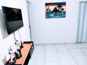 a living room with a flat screen tv on a table at Apartamento Maravilhoso 2 Quartos Suíte Privativa no Boqueirão em Santos in Santos