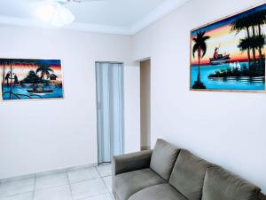 a living room with a couch and a painting on the wall at Apartamento Maravilhoso 2 Quartos Suíte Privativa no Boqueirão em Santos in Santos