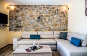 a living room with a couch and a stone wall at Aeri in Prinos