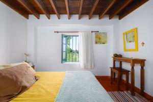 ein Schlafzimmer mit einem Bett und einem Fenster in der Unterkunft Casa do Lenho in Achadinha