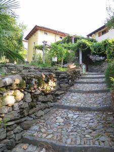 un chemin en pierre avec un mur en pierre et un bâtiment dans l'établissement Da Erminia, à Verdabbio