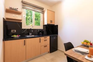 a kitchen with wooden cabinets and a table and a window at Am Meer Suite in Argostoli