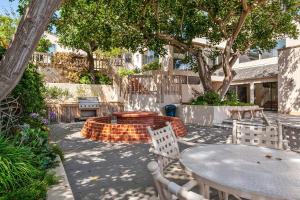 a patio with a table and chairs under a tree at Tranquil Living - SUR4 in Solana Beach