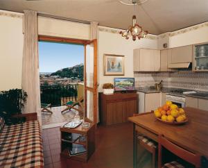 a kitchen with a table with a bowl of fruit on it at Residence i Morelli in Pietra Ligure