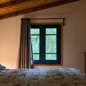 a bedroom with a bed and a window at Lila Casas de Montaña in La Cumbrecita