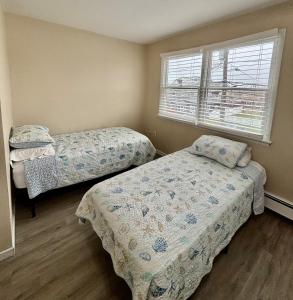 ein Schlafzimmer mit zwei Betten und einem Fenster in der Unterkunft 2 story beach house 3-Bedroom 2 baths Home 2 Blocks from the Ocean & Boardwalk Seaside heights in Seaside Heights