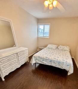 ein Schlafzimmer mit einem Bett, einer Kommode und einem Spiegel in der Unterkunft 2 story beach house 3-Bedroom 2 baths Home 2 Blocks from the Ocean & Boardwalk Seaside heights in Seaside Heights
