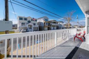 eine rote Bank auf der Veranda eines Hauses in der Unterkunft 2 story beach house 3-Bedroom 2 baths Home 2 Blocks from the Ocean & Boardwalk Seaside heights in Seaside Heights