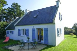une petite maison blanche avec une table et des chaises dans l'établissement Classic Breton holiday home in Sarzeau, à Sarzeau