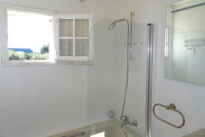 une salle de bain blanche avec une douche et un lavabo dans l'établissement Classic Breton holiday home in Sarzeau, à Sarzeau
