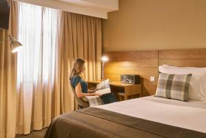 a woman sitting at a desk in a hotel room at PortoBay Marquês in Lisbon +22 photos