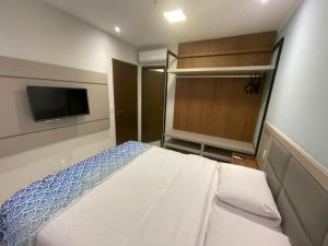 a bedroom with a bed and a flat screen tv at Aqualand Resort in Salinópolis