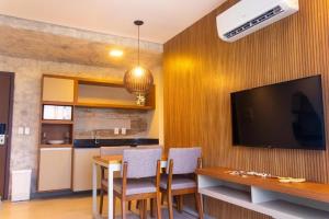 a dining room with a table and a television on a wall at Aqualand Resort in Salinópolis